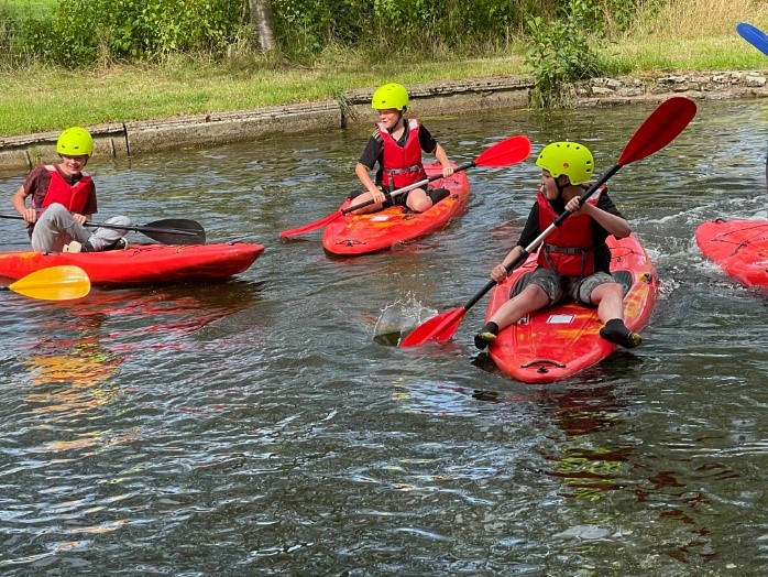 young people kayaking in a river